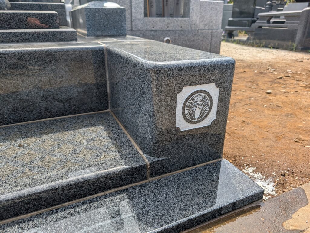 代替テキスト：外柵袖石に設置した家紋プレート