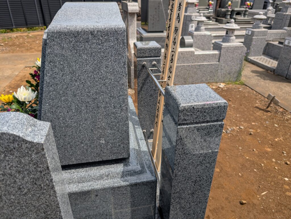 代替テキスト：ステンレス製の塔婆立てを備えた洋型墓石背面