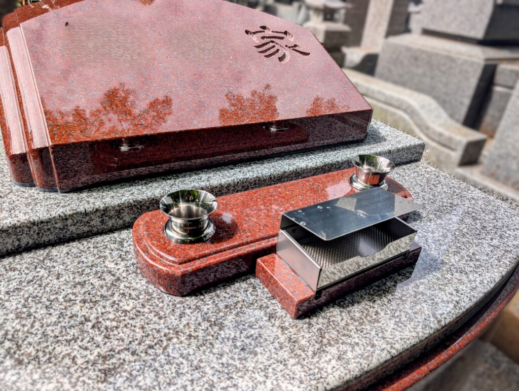 画像代替テキスト：赤御影石の花立てを2つ設けたさくらふわりぼ光の正面部分